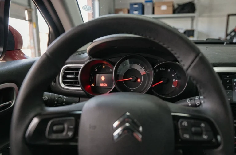 Voyant batterie rouge clignotant sur le tableau de bord d'une Citroën C3 à l'arrêt dans un garage
